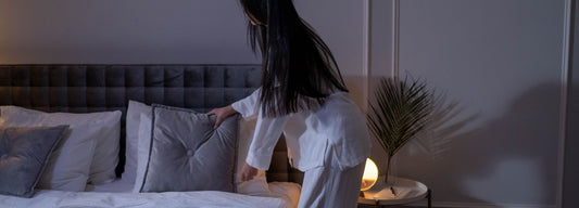 A person getting ready for bed in a dimly lit bedroom